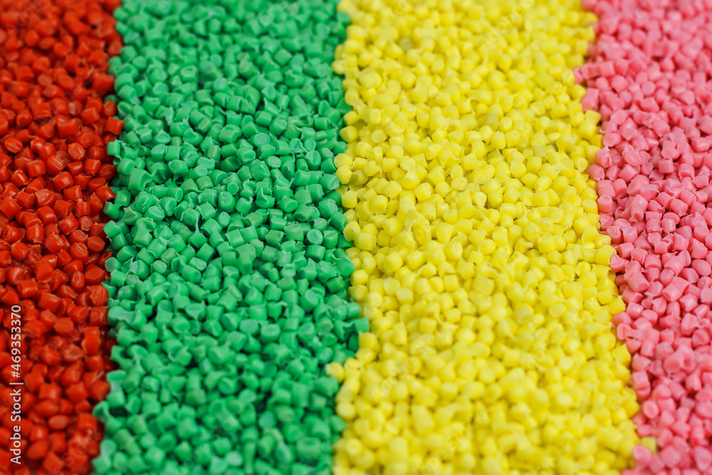 Lots of green, blue, red, yellow, pink granules of polypropylene, polyamide. Chemical products. Plastic, polymers and microplastics.