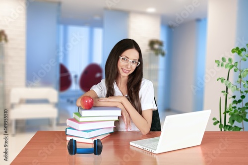 Smiling woman listening educational online lecture, writing notes