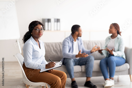 Female psychologist and young black couple having conflict during marital therapy at office, copy space