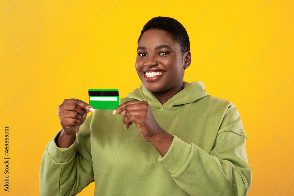 Happy African Lady Showing Credit Card Posing Over Yellow Background Happy African Lady Showing Credit Card Posing Over Yellow Background
