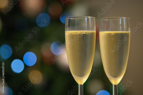 Champagne glasses over holiday bokeh blinking background, glasses with sparkling wine, celebration, party. High quality 4k footage