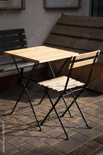 Wooden table with a chair outside.