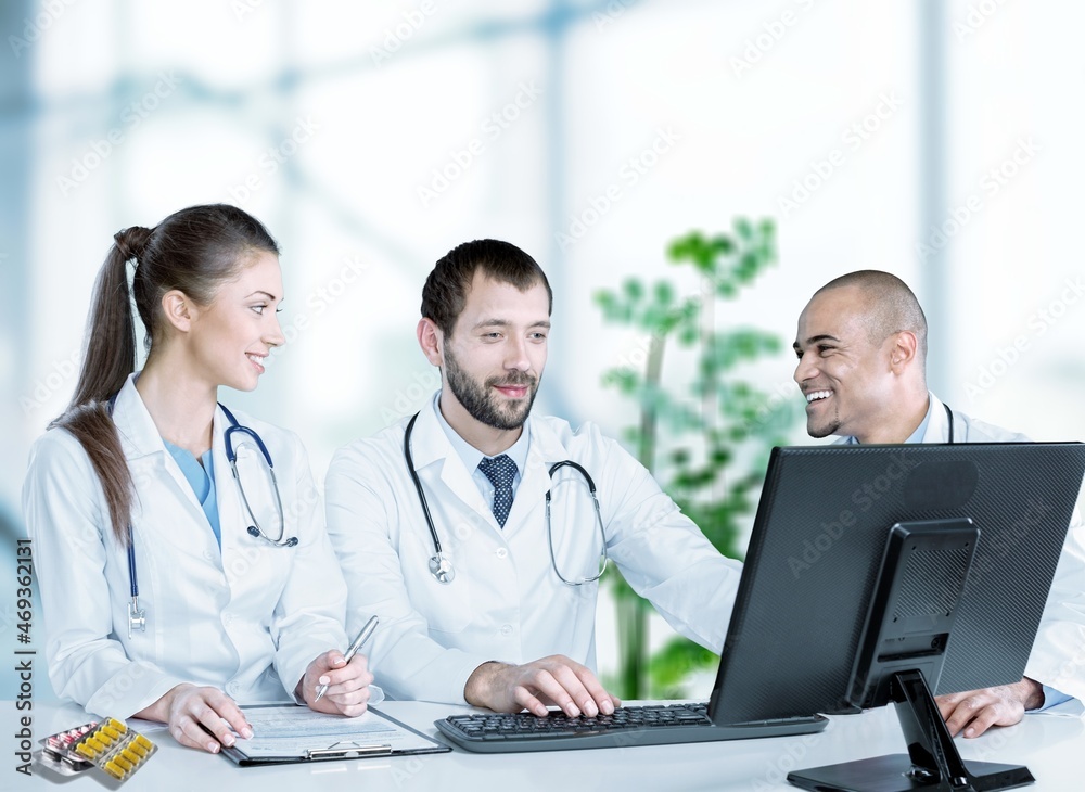 Doctor talking to an online patient on laptop screen sitting at clinic office, online consultation