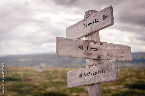 seek true wealth text on wooden sign outdoors in nature. Religious and christianity quotes.