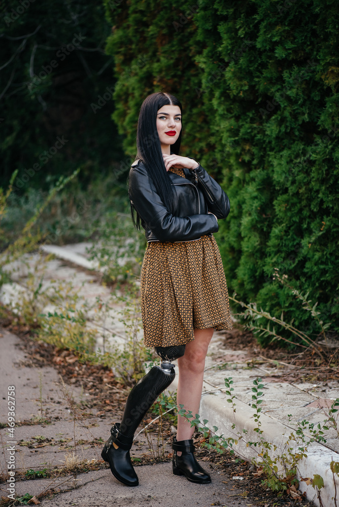 Beautiful girl with a prosthetic leg posing on the street. Beautiful girl with a prosthetic leg posing on the street.