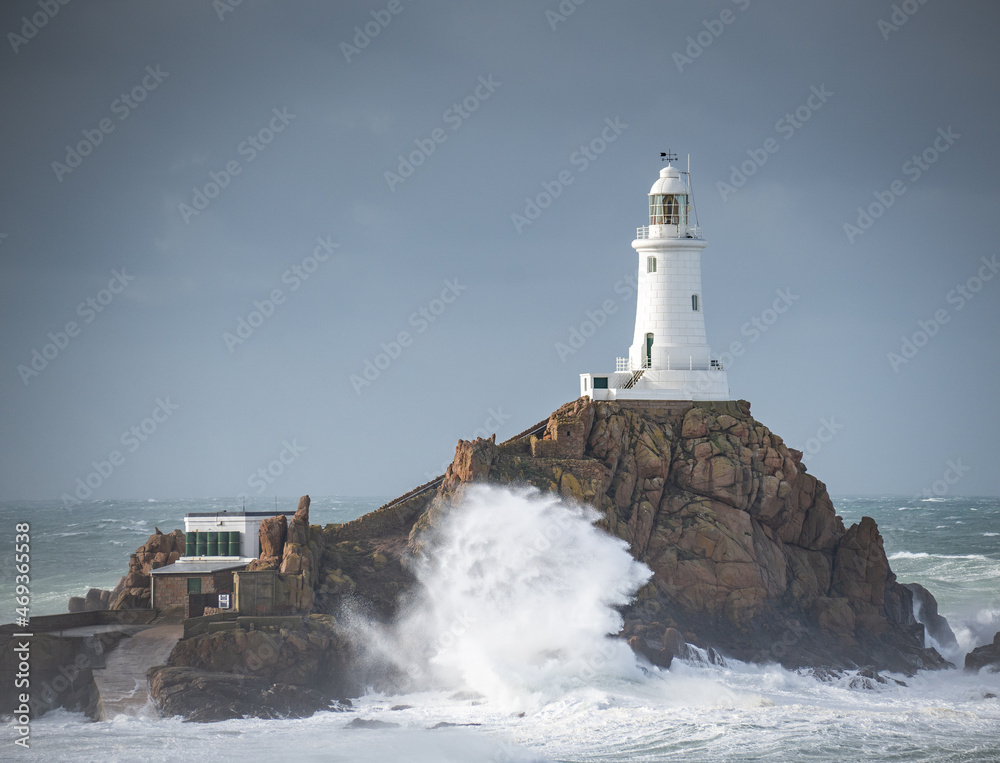 lighthouse on the rocks during the storm