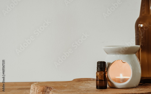 Photography Candle warmer and glass bottle on wooden desk. Copy space.