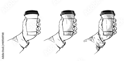 the hand holds a paper cup with coffee. hand drawing engraving