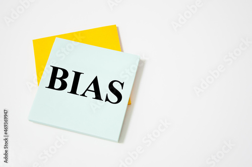 bias text written on a white notepad with colored pencils and a yellow background. word