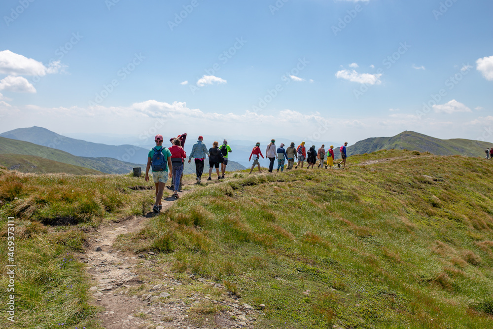 Obraz premium a large group of people goes hiking, walks in the mountains