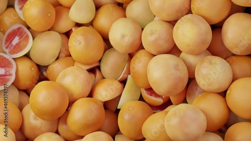 Grapefruits and oranges fall into a box. Fruit is poured into a box. loading of fruit for transportation
