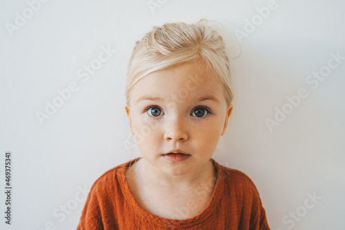 Child girl cute blonde hair baby at home toddler looking at camera portrait 3 years old kid family lifestyle