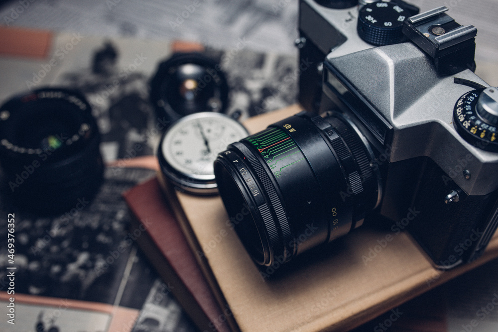 old camera, glasses and watch on newspaper background