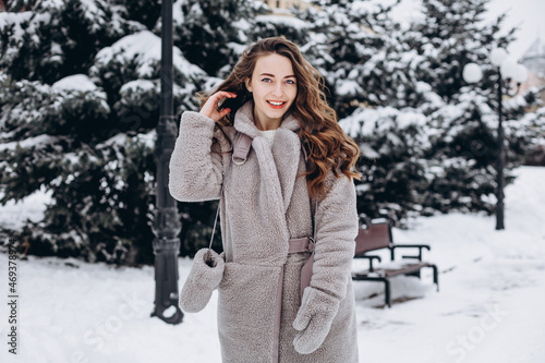 Pretty girl having a walk in park at winter looking at camera