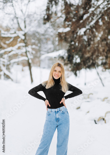 Close-up winter portrait of young woman with blond hair in the park © Yuliia