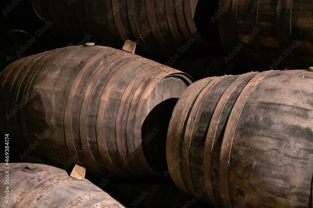 Old porto lodge with rows of oak wooden casks for slow aging of fortified ruby or tawny porto wine in Vila Nova de Gaia, Portugal Old porto lodge with rows of oak wooden casks for slow aging of fortified ruby or tawny porto wine in Vila Nova de Gaia, Portugal