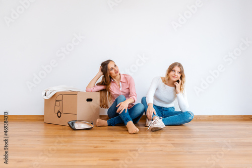 Two women in new apartment dreaming of how to decorate it photo