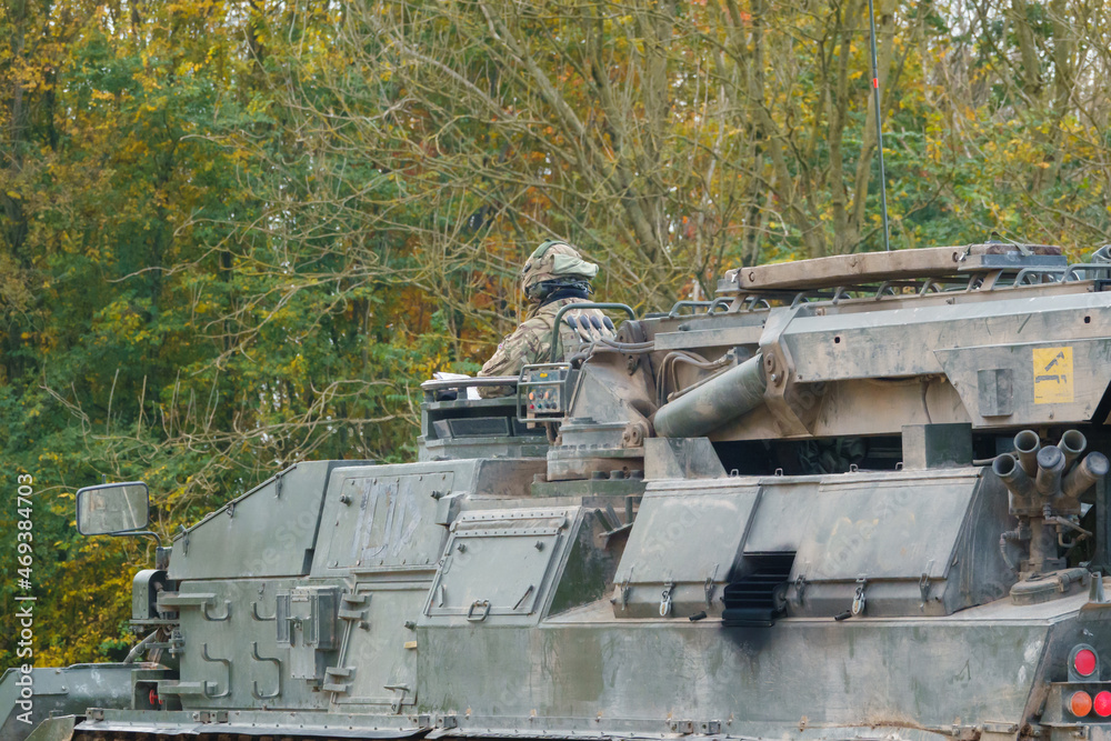 close up rear three-quarter shot of a British Army Challenger Armored Repair and Recovery Vehicle (CRARRV) with visible Commander in action on a military training exercise, Salisbury Plain UK