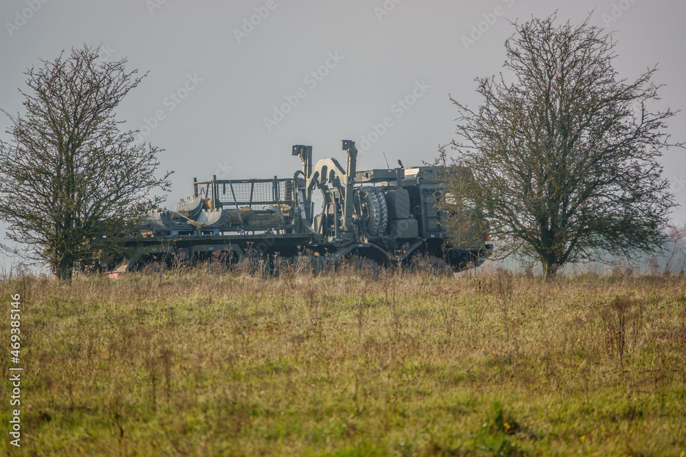 MAN SV 8x8 army logistics truck vehicle with cargo driving along a mud track in action on a military exercise, Salisbury Plain UK MAN SV 8x8 army logistics truck vehicle with cargo driving along a mud track in action on a military exercise, Salisbury Plain UK