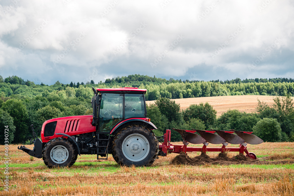 Obraz premium Farmer in tractor plowing the land in autumn