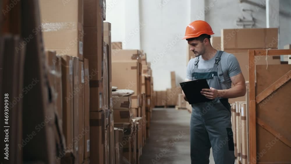Young male worker in warehouse walks forward with pallet truck Young male worker in warehouse walks forward with pallet truck