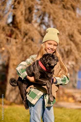 Pretty blonde girl holding her dog and smiling