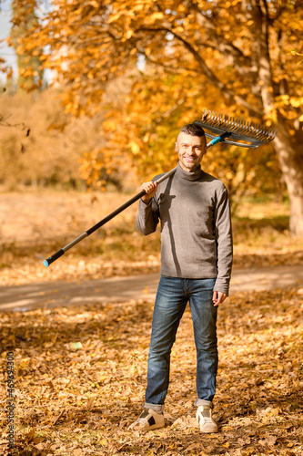 A man with a rake standing in the park