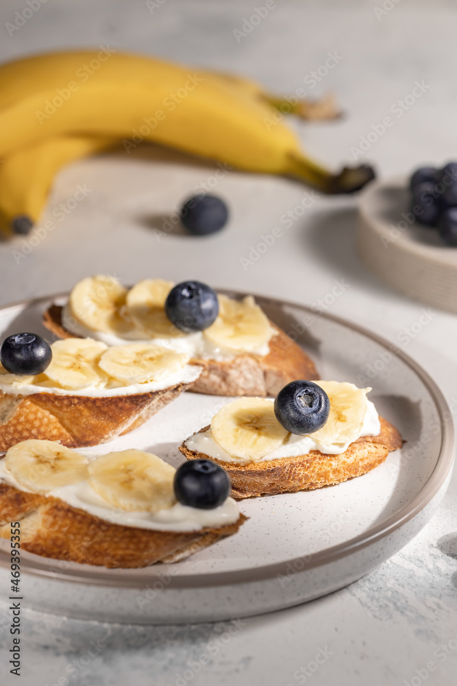Healthy breakfast concept, banana sandwiches with blueberry on round plate on the table