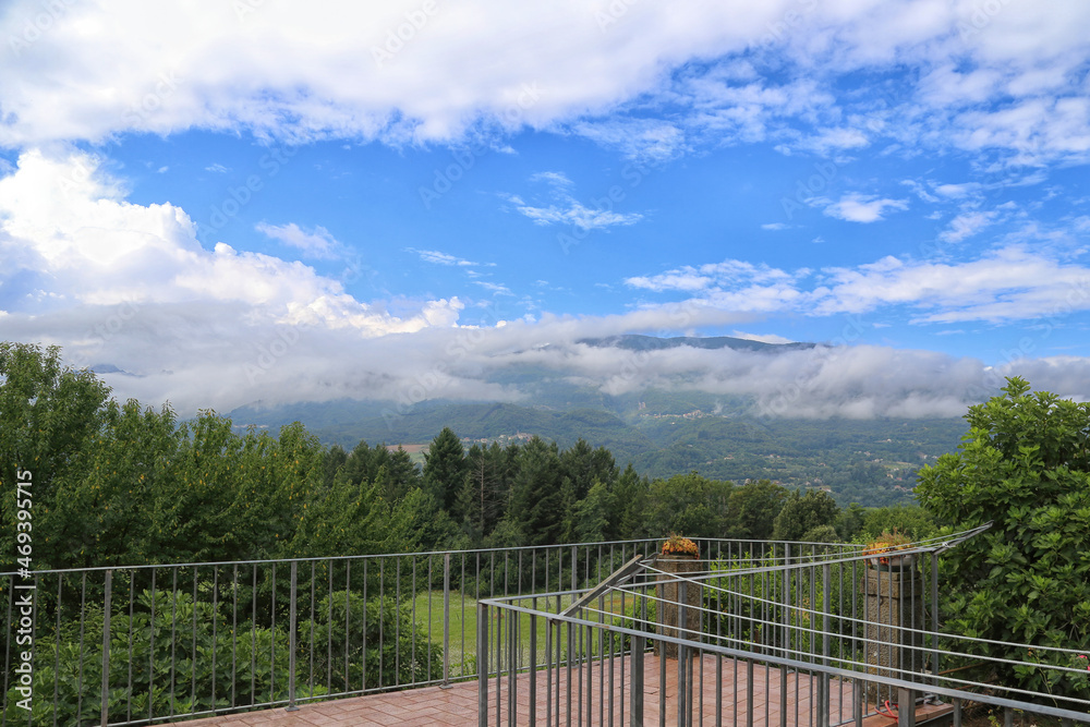 Fototapeta premium Scenic view of Mountains, trees and green landscape by a balcony in Tuscany
