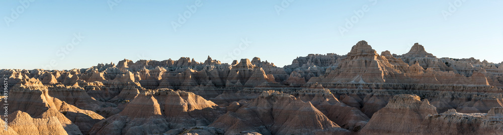 Jagged sandstone mountains illuminated from the sun in Badlands National Park