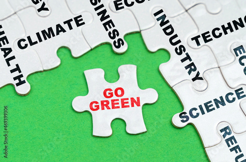 On a green background, white puzzles with text, a puzzle with the inscription - Go Green