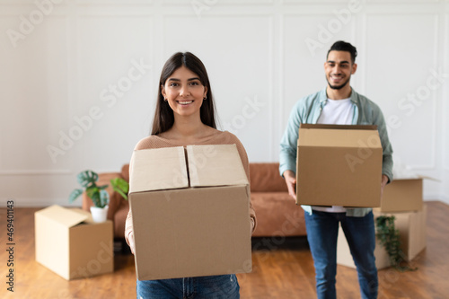 Happy couple holding cardboard boxes, relocation concept