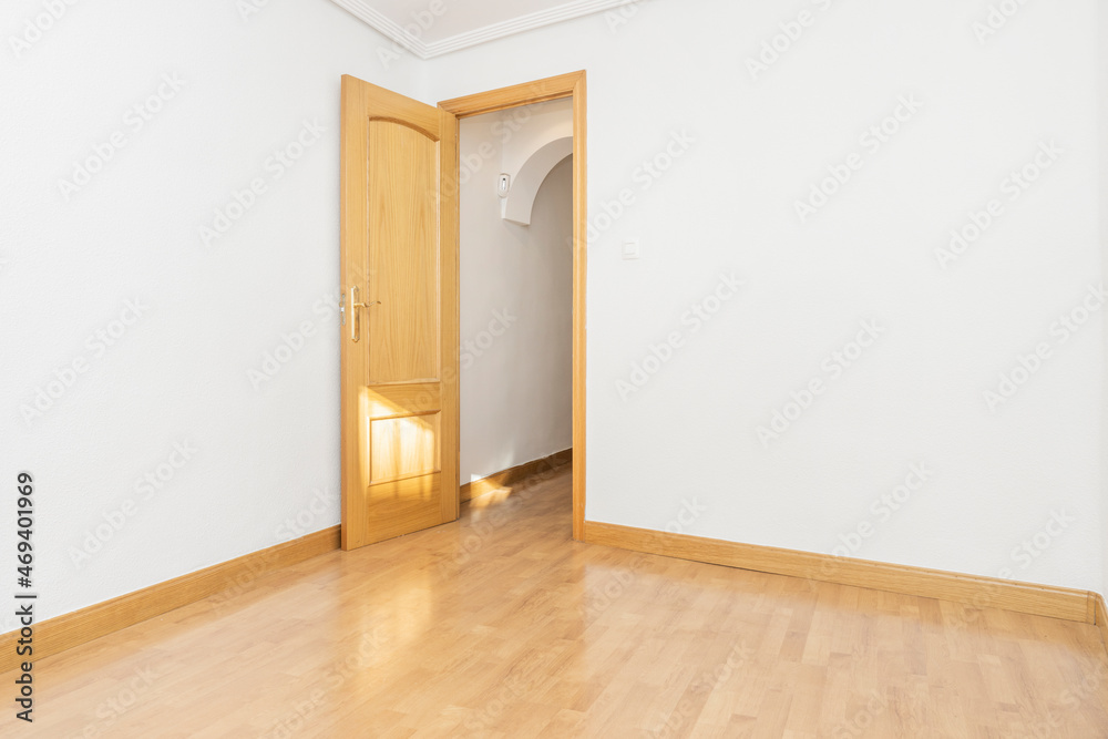 Empty room with light oak floors and carpentry with white painted walls Empty room with light oak floors and carpentry with white painted walls
