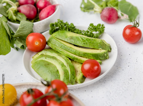fresh vegetables and avocado slices on a plate