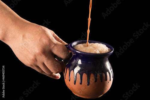 Traditional Mexican hot chocolate in a handmade pot a sample of Latin American cuisine on a black background with copy space photo