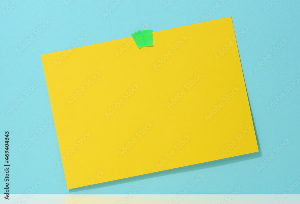 blank rectangular yellow sheet of paper glued on a blue background. Place for an inscription, announcement blank rectangular yellow sheet of paper glued on a blue background. Place for an inscription, announcement