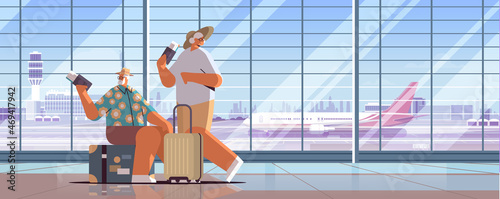 elderly couple of tourists grandparents with luggage holding passports and tickets ready to boarding at airport