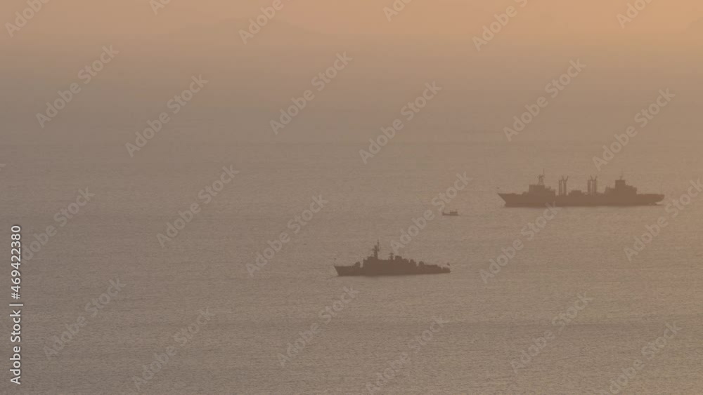 Ships near coastline on sunset at golden time. Calm idyllic sea blue water surface Ships near coastline on sunset at golden time. Calm idyllic sea blue water surface
