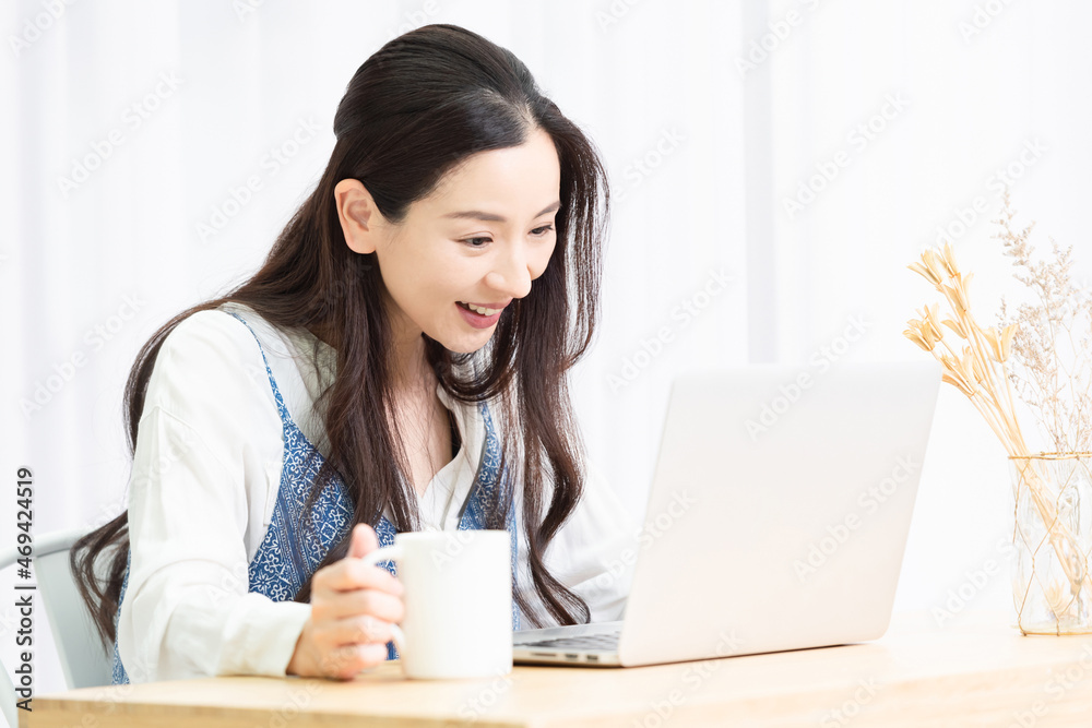 リビングでノートパソコンを使う主婦 リビングでノートパソコンを使う主婦