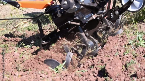 Farmer plows the land with a cultivator, Agricultural machinery mini tractor in the field