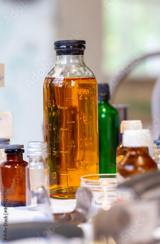 Glass flask with orange liquid on laboratory table