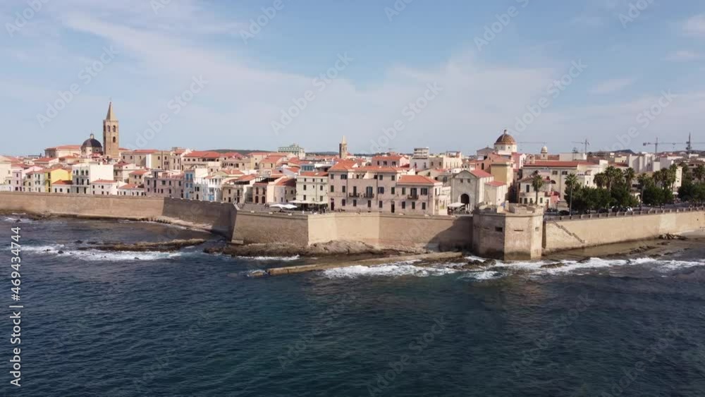 Beatiful drone clip of the traditional town of Alghero in Sardinia, Italy with the walls and a cathedral in the background Beatiful drone clip of the traditional town of Alghero in Sardinia, Italy with the walls and a cathedral in the background