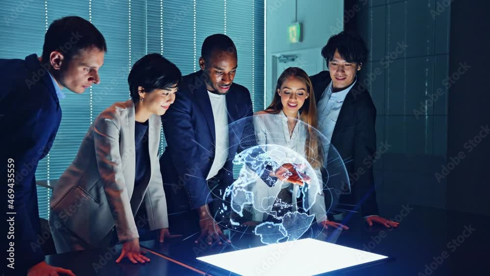 Multi racial group watching hologram of the earth in dark office. Global network.
