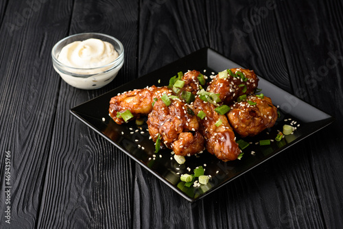 Korean fried chicken with black backdrop.