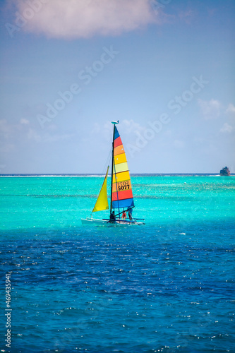 Small colorful sailboat sailing in the blue and transparent waters of the island of San Andres.