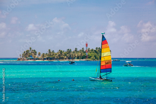 Small colorful sailboat sailing in the blue and transparent waters of the island of San Andres. photo