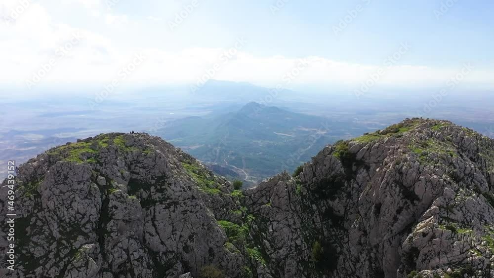 Drone shot moving forwards between the two peaks to reveal the epic and dramatic view of the landscape down below in the valley of Zaghouan in Tunisia.