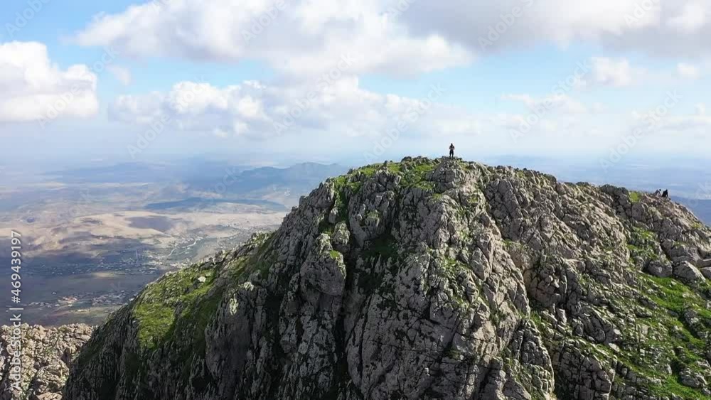 Drone shot flying upwards and forwards from the cliffside of the mountain and above a person standing on the edge looking down over the epic view Drone shot flying upwards and forwards from the cliffside of the mountain and above a person standing on the edge looking down over the epic view