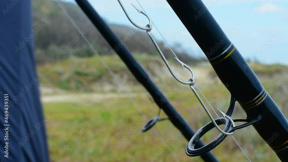 High quality close up of fishing rods and gang hooks with super shallow depth of field, ready for some beach fishing on a windy day High quality close up of fishing rods and gang hooks with super shallow depth of field, ready for some beach fishing on a windy day