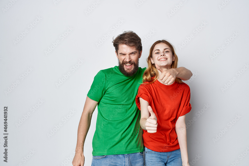a young couple multicolored t-shirts communication quarrel isolated background a young couple multicolored t-shirts communication quarrel isolated background